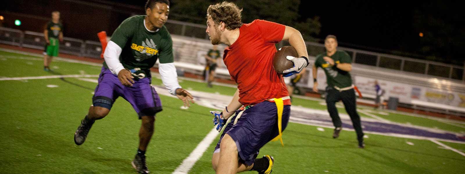 students playing flag football at night